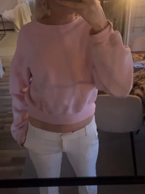 Ljusrosa croppad hoodie - Säljer en ljusrosa sweatshirt med rund hals, är enkel och stilren, perfekt för en chill och avslappnad look. 