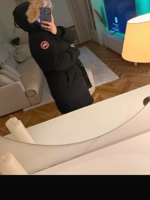 Canada goose jacka  - Storlek L. Dragkedjan och knappen längst ner fungerar inte, se bilder. Man kan knäppa jackan med knapparna eller gå till en sömmerska och fixa dragkedjan. 