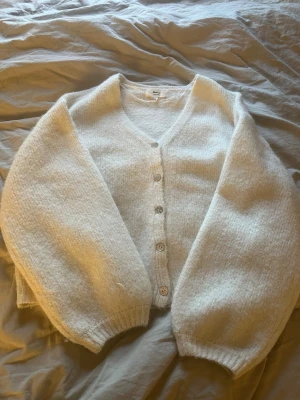 Vit kofta från Gina Tricot - Mysig vit kofta från Gina Tricot i ullblandning. Koftan har v-ringning, långa ärmar och stängs med fyra knappar framtill. Perfekt för lager på lager och har en avslappnad passform med ribbade muddar. Använt en gång men tyckte inte om den super mycket på mig själv. Priset för att diskuteras💞