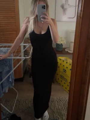 Svart långklänning med smala axelband - Säljer en svart långklänning med smala axelband och figurnära passform. Klänningen har en enkel och stilren design med rundad halsringning och ärmlös modell. Från Shein i storlek Xs💞