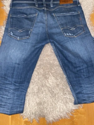 Blå raka jeans från Jack & Jones - Snygga blå jeans från Jack & Jones med raka ben och slitna detaljer framtill. Klassisk femficksmodell med kontrastsömmar och läderpatch bak i midjan. Jeansen är i denim och har en cool tvättad look. Det går att skriva och förhandla pris😁