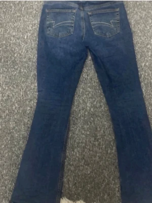 Blå bootcut jeans med mönstrade fickor  - Snygga blå jeans med bootcut passform med häftiga fickor. Klassisk femficksmodell i mjukt denimtyg, perfekt för dig som gillar en tidlös look. Nästintill nya!!