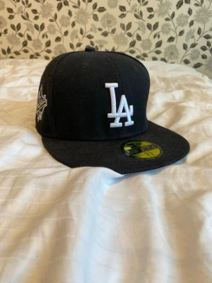 LA Dodgers keps New Era - Svart keps från New Era med LA Dodgers-logga, klassisk flat peak.