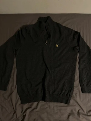 Svart halvzip-tröja från Lyle & Scott - Mörk, stilren halvzip-tröja från Lyle & Scott. Är i ganska bra skick och har inte använts länge. 
