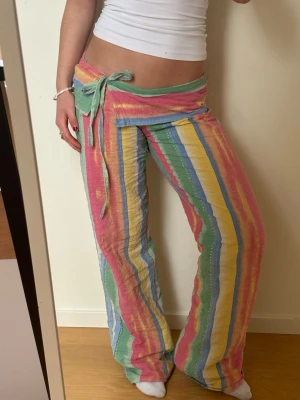 Färgglada randiga low waist byxor med knytband - Säljer dessa fantastiska byxor!! 💕💕De är lågmidjade, sydda i ett randigt färglagt tyg av bomull. De är sydda av mig och är därför helt unika! Likande dom från beshka. Passar ca s, jag är 162 cm. Har ett snöre i midjan där man kan spänna in, men de är inte stretchig så kan vara svåra att få på sig. Ställ gärna frågor och kika gärna på mina andra annonser! Kommer även ladda upp fler saker jag sytt till våren/sommaren, så följ gärna. 💗💕 obs ser nästan ut som på bilden!!