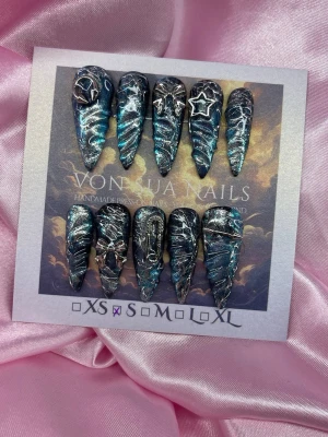 GalaxyVenom (S);Long Stiletto - Unika handgjorda press-on naglar i svart och blått med metallic-effekt, silverdetaljer och 3D-dekorationer som stjärnor och kedjor. Långa, spetsiga och dramatiska – perfekta för dig som vill sticka ut. S: 15 mm, 11,5 mm, 12 mm, 11 mm, 9 mm 