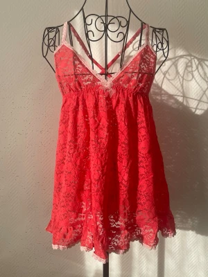 Rött spetsnattlinne från Victoria’s Secret - Sött rött nattlinne i spets med tunna axelband och en liten rosett framtill. Storlek: L, passar 38-40. Dockans storlek: 34.