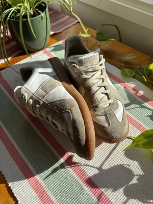 Maison Margiela GATs - Ett par sjukt clean skor från Maison Margiela som passar perfekt nu när vår och sommar är på ingång!🌤️👞| Köptes med Vinteds äkthetsverifiering där de skickas till en fysisk verifieringscentral med proffs!🕵🏼| Hör av dig vid frågor! 