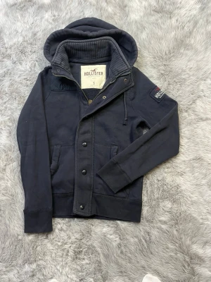 Hollister Cardigan - Säljer denna sällsynta och mycket eftertraktade Hollister hoodie/Cardigan, Skick 8/10. Perfekt nu till blivande sommarkvällar! Hör av dig vid frågor och funderingar, pris diskuteras vid snabb affär🗽