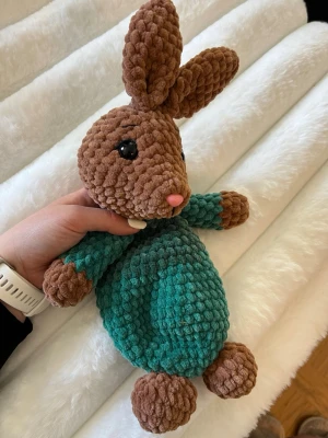 Kanin snuggle grön - Detta säljer jag åt min kompis som har virkat denna fina fina bruna kanin med grön klädsel, huvudet, armarna och fötterna är stoppade men inte magen så det blir en snuggle😊🫶🏼
