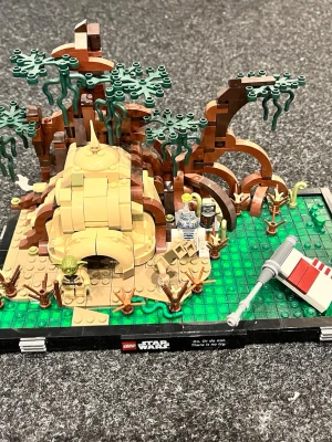 LEGO Star Wars Dagobah diorama - Säljer ett LEGO Star Wars Dagobah diorama med Yodas hydda, träd, grön bas och minifigurer av Yoda, Luke Skywalker och R2-D2. Setet har detaljer som trädkronor, rötter och en del av ett rymdskepp. Alla delar medföljer + reservdelar. Perfekt för Star Wars-fans och samlare. Produkten går ej att köpa hos Lego längre. Skickas nerplickat i påsar om inget annat önskas