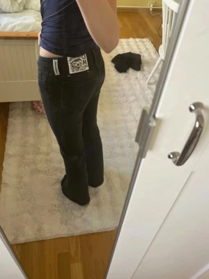 Svarta bootcut jeans från cheap monday  - Säljer ett par svarta bootcut jeans från cheap monday med klassisk femficksdesign och låg midja. Jeansen har en snygg passform som sitter tajt upptill och släpper ut vid benen. Perfekta för dig som gillar en tidlös och cool stil. Storlek 27/32
