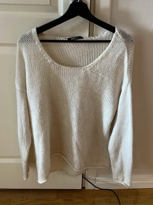 Vit stickad tröja från Gina Tricot - Säljer en vit stickad tröja från Gina Tricot med rund halsringning och lång ärm. Tröjan har en lös passform och är stickad i ett mjukt material, perfekt för lager-på-lager och chill dagar.