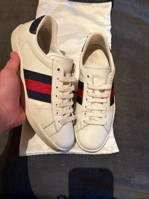 Gucci ace|41,5 - Gucci ace| Storlek 41,5 passar 42| Skick 8/10 lite skador baktill inget som syns| nypris ca 10000kr| dust och kort finns vid fullpris (1999kr)| Innermått 27cm|Sell.ArchiveSS|
