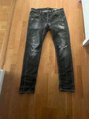Svarta replay jeans med slitningar - Tjena! Säljer ett par riktigt snygga svarta Replay-jeans med feta slitningar och en stilren wash. Jeansen är i toppskick (9,5/10) utan några defekter. De är dessutom ganska sällsynta, så här har du chansen att lägga vantarna på ett unikt plagg till ett bra pris. Storlek: W33 L34. Kontakta mig gärna ifall du har frågor!🙂