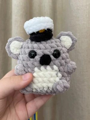 Handvirkat studenthänge – koala med studentmössa - Handvirkad koala med studentmössa och blågult band. En personlig studentpresent som är lätt att bära runt halsen under firandet och blir ett fint minne efteråt. Tillverkad i mjukt garn med noggrant gjorda detaljer och ett unikt uttryck. Passar perfekt till studenten 2026.
