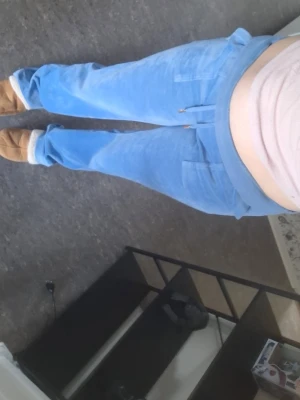 Blå juicy couture byxor - Säljer ett par ljusblå juicy couture byxor i mjuk velour med raka ben och resår i midjan. Byxorna har dragsko och två framfickor. Perfekta för chill dagar hemma eller när du vill vara extra bekväm, dom är använda ett par gånger, när jag köpte dem var dem redan nertrampade, de e lite missfärgning längst ner på byxorna men annars är det bra 