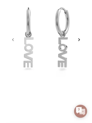 Silverfärgade EDBLAD örhängen med LOVE-hänge - Snygga örhängen i silverfärgad metall med hängande texten 'LOVE' i blockbokstäver. Runda hoops med modern och stilren design, perfekta för att ge din look en cool touch. Passar dig som gillar statement-smycken och trendiga accessoarer.