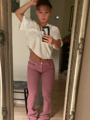 Rosa bootcut jeans med låg midja - Säljer ett par snygga vintage jeans i rosa med låg midja och utsväng passform. Skit coola och unika som inte längre säljs. Storlek 38. Stretch i materialet. Figurnära passform som formar kroppen bra. Najs om man vill styla unik stockholmstil eller chic Copenhagen style. Säljes då jag har mycket liknande plagg! Först till kvarn, pris kan diskuteras (: