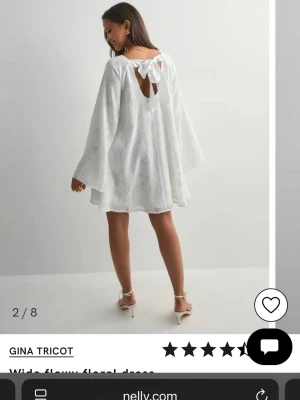Vit blommig klänning från Gina Tricot - Superfin vit klänning från Gina Tricot med blommigt mönster, vida ärmar och en söt rosett i ryggen. Klänningen har en lös passform och är perfekt för varma dagar. Den har en öppen ryggdetalj och är tillverkad i ett lätt material.