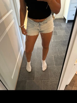 Ljusblå denimshorts med fransar - Snygga ljusblå denimshorts med fransiga kanter och klassisk femficksdesign. 