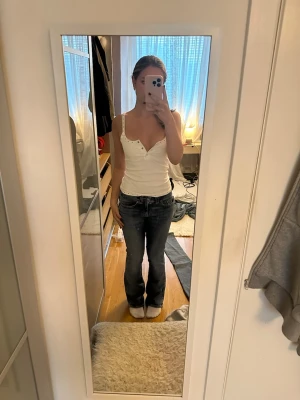 Mörkblå bootcut jeans - Snygga mörkblå bootcut jeans med klassisk femficksdesign och låg midja. Jeansen har en lätt tvättad look och raka ben som går ut lite nertill. Perfekta för en avslappnad och trendig stil.