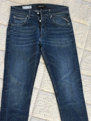 Replay Grover jeans - Snygga mörkblå jeans från Replay med klassisk femficksmodell och diskreta slitningar. Jeansen är straight fit och läderpatch med logga bak i midjan. 