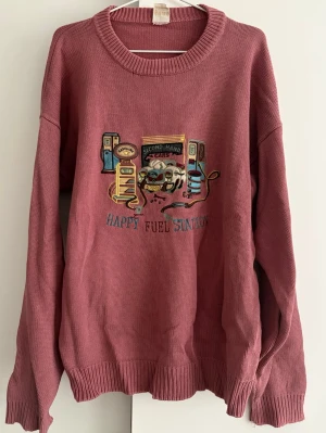 Rosa stickad tröja med brodyr - Cool vintage stickad tröja. Tröjan har rund halsringning, långa ärmar och ribbade muddar. 
