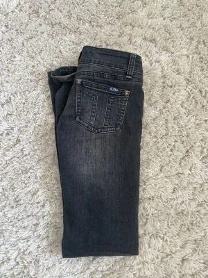 Mörkgrå G-Rise jeans - Snygga mörkgrå jeans från G-Rise med klassisk femficksmodell och diskreta slitningar framtill. Jeansen har raka ben och väldigt låg midja. Tillverkade i stretchigt denimtyg för extra komfort. Perfekta för en avslappnad och trendig look.