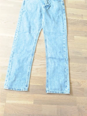 Ljusblå raka jeans från Jack & Jones - Säljer ett par ljusblå raka jeans från Jack & Jones med klassisk femficksmodell och hög midja. Jeansen har en avslappnad passform och är tillverkade i kraftigt bomullsdenim. Perfekta för en casual och trendig look.