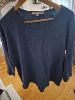 Mörkblå tröja från Flash Woman - Mysig mörkblå tröja från Flash Woman med rund halsringning och långa ärmar. Perfekt för lager på lager och enkel att matcha med olika stilar. Materialet känns mjukt och bekvämt mot huden.