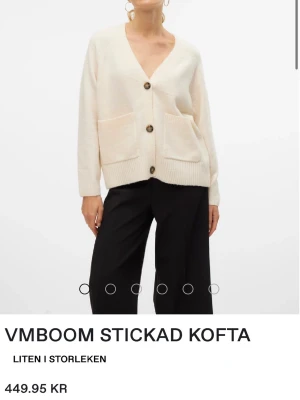 Vit stickad kofta från Vero Moda - Säljer en krämvit stickad kofta från Vero Moda med stora bruna knappar och två framfickor. Koftan har v-ringning, ribbade muddar och en avslappnad passform. Den blir lurvig lätt