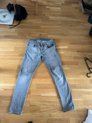 Ljusgrå slimfit jeans från g-star - Säljer ett par ljusgrå jeans med rak passform och klassisk femficksdesign. Jeansen har bälteshällor, dragkedjegylf och knappstängning. Materialet är denim i bomull. Perfekta för en avslappnad och stilren look. Har trasig del bak som visas i bilderna. Pris kan diskuteras vid snabb köp