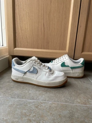 Nike air force 1 - I fint skick! Använda ett tio tal gånger. Inga fläckar, men lite slitage syns på de 4 sista bilderna. De blå o gröna detaljerna är i mocka.