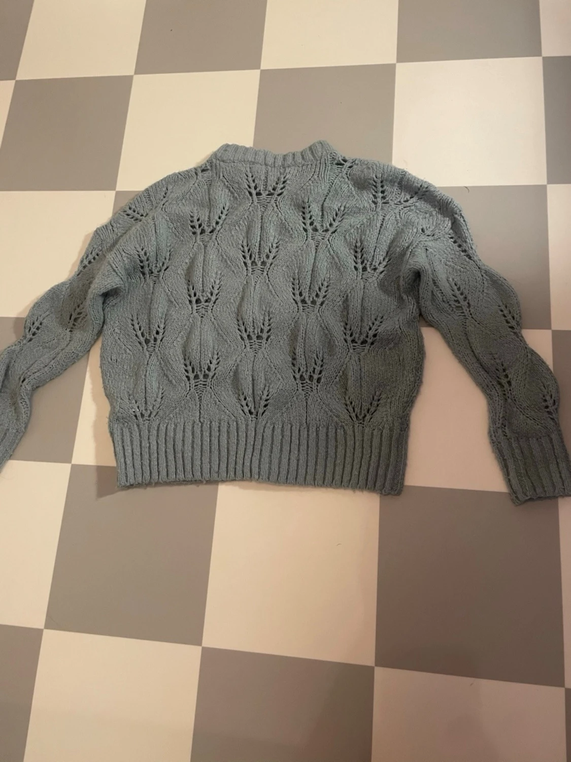 Blå stickad tröja med hålmönster