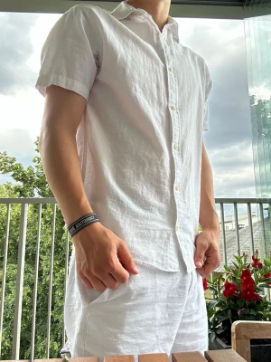 Vit linneskjorta  - En snygg vit linneskjorta perfekt inför sommaren. Den har en avslappnande look och använd få tal gånger, köpt för cirka 1-2 månader sedan.
