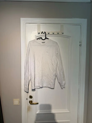 Vit långärmad tröja från Weekday - Säljer en enkel och stilren vit långärmad tröja från Weekday i storlek XS. Tröjan har rund halsringning och är gjord i mjukt bomullsmaterial. Perfekt basplagg att matcha med olika outfits.