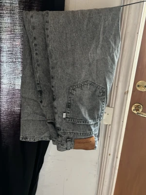 Grå jeans från Woodbird - Snygga grå jeans från Woodbird i modellen Leroy Ash. Jeansen har en avslappnad passform, stora fickor och är tillverkade i ekologisk bomull. Perfekta för en trendig och avslappnad stil.