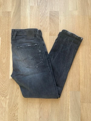 Grå Replay Anbass jeans W32 - Jag säljer dom här riktigt snygga Replay Anbass jeansen i storlek W32. De har väldigt snygga slitningar. Tveka inte att höra av er! Mått: Längd=95cm Midja=43cm