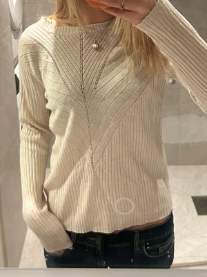 Beige ribbad tröja med mönster - Säljer en beige ribbad långärmad tröja med snyggt stickat mönster framtill