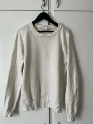 Vit stickad tröja från VILA - Klassisk vit stickad tröja från VILA med rund halsringning och ribbade muddar vid ärmslut och nederkant. Enkel och stilren design som passar till allt. Tillverkad i mjukt material för en bekväm känsla.