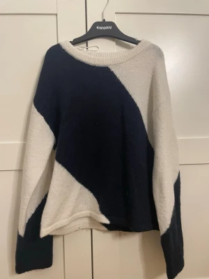 Stickad tröja med svartvita block - Säljer en stickad tröja från Gina  med stora block i svart och vitt. Tröjan har rund halsringning, lång ärm och en avslappnad passform. Perfekt för dig som gillar grafiska mönster och vill ha något mjukt och bekvämt.