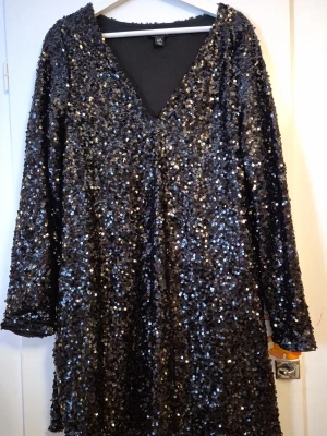 Svart klänning med paljetter - Svårt klänning med paljetter. Storlek 42