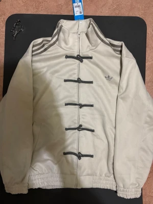 Adidas chinese/lunar jacka - Unik beige jacka från Adidas kollektionen. Väldigt svårt att få tag på