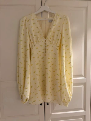 Ljusgul blommig klänning från Adoore - Supersöt ljusgul kortklänning från Adoore, använt 1 gång men är förliten nu då jag säljer den💕