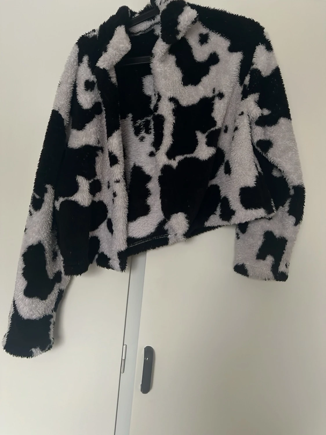 Svartvit teddyjacka med koskinnsmönster