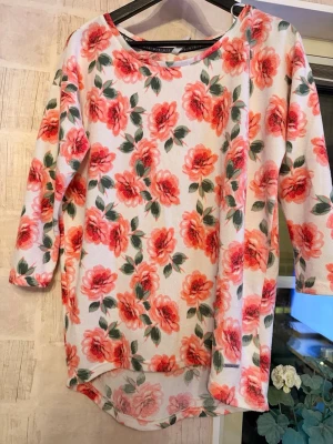 Blommig tröja, S - Blommig tröja från Hailys i storlek S. Mjukt material. Fint skick. Avslappnad passform som är längre baktill. Material: 95% polyester 5% elastan