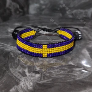 Handgjort Armband Svenska Flaggan - ✨️Justerbart, enkelt att öppna och stänga ✨️Kan stängas till en 15cm omkrets och öppnas bredast till ca 27cm omkrets ✨️Höjden av flagg-delen är 1,3cm ✨️Flagg-delen minus "glidknuten" är 14cm lång ✨️Skickas inom en vecka så fort tillverkningen är klar