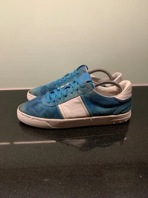 Valentino flycrews - Snygga valentino flycrews i blå mocka och vitt läder. De har släppt lite där framme. Skorna har blå skosnören, vit sula och klassisk låg siluett. Perfekta för dig som vill ha en stilren och unik look med premiumkänsla. Passar till jeans eller shorts för en avslappnad vibe. Skickar inom 2 dagar! Storlek 42 i mycket bra skick. Priset kan diskuteras!