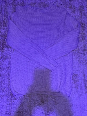 Beige stickad tröja - En enkel och stilren beige stickad tröja med rund halsringning och långa ärmar. Tröjan har en mjuk struktur och ribbade muddar vid ärmslut och nederkant. Perfekt för lager på lager och passar till det mesta.